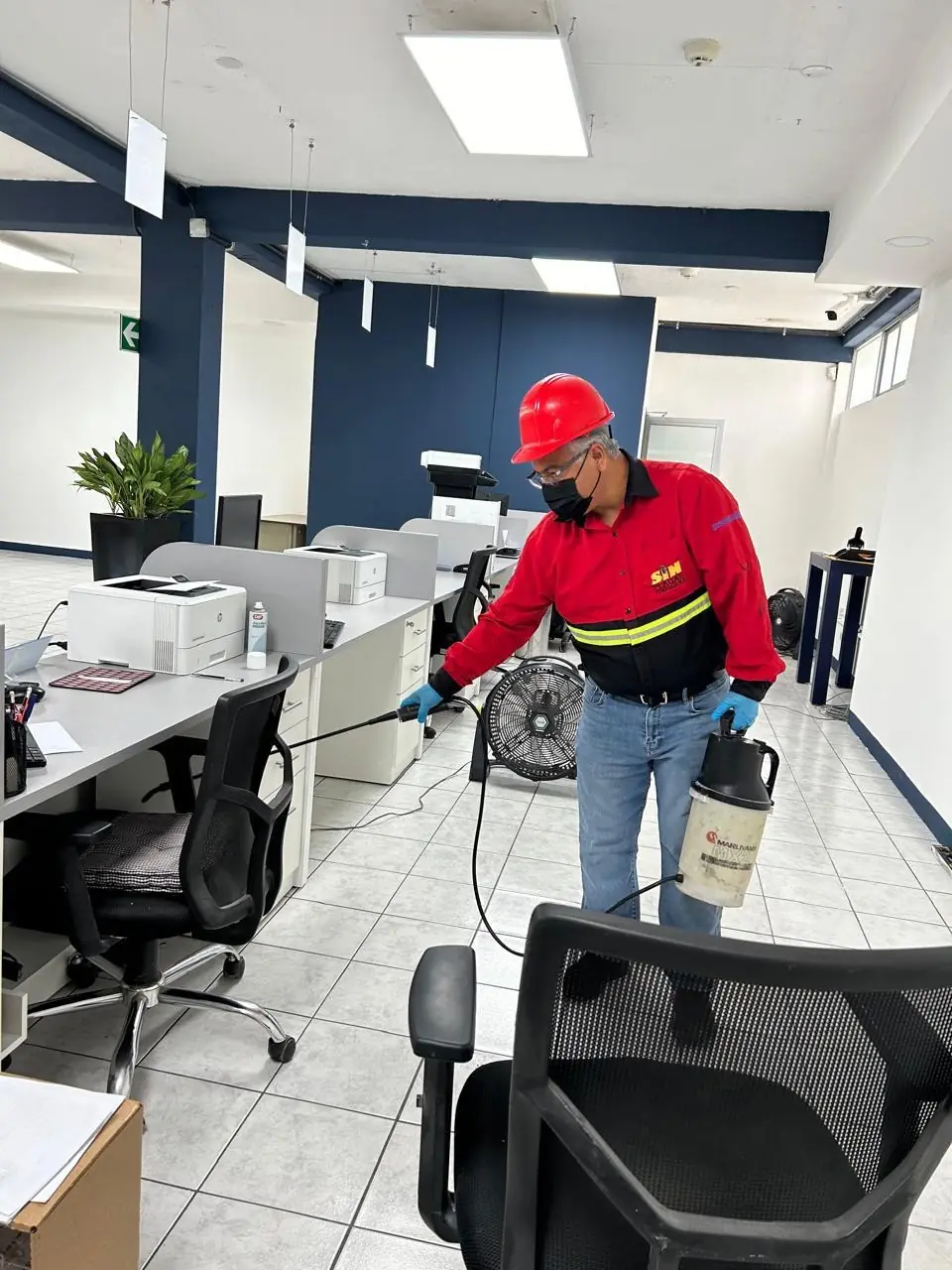 Técnico de Sin Plagas aplicando control de plagas en oficinas corporativas