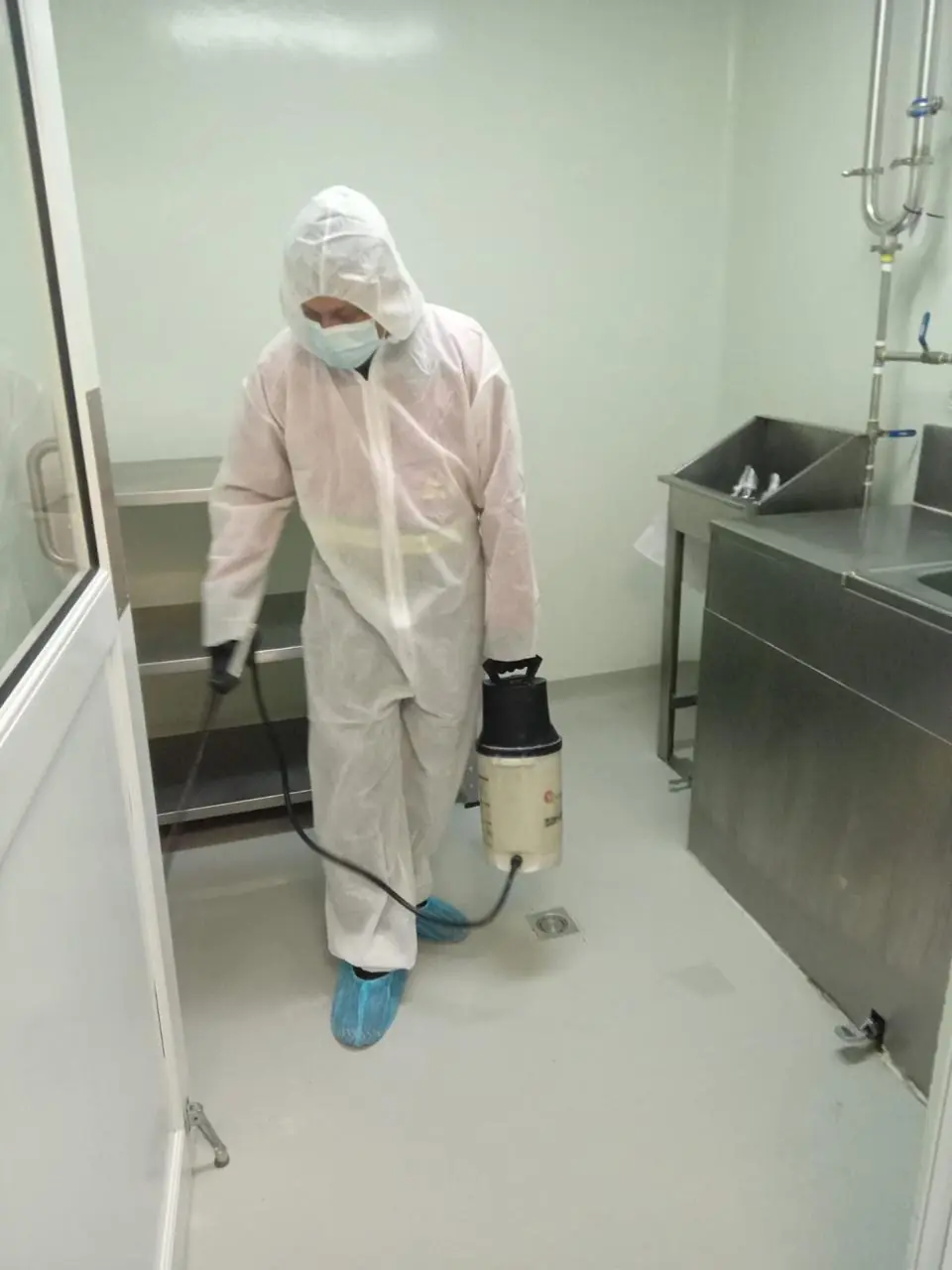 Técnico con traje de protección en área de inocuidad de planta de alimentos